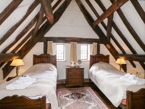 Duas camas num quarto no sótão com vigas de madeira em Gatehouse Croft em Newton Regis