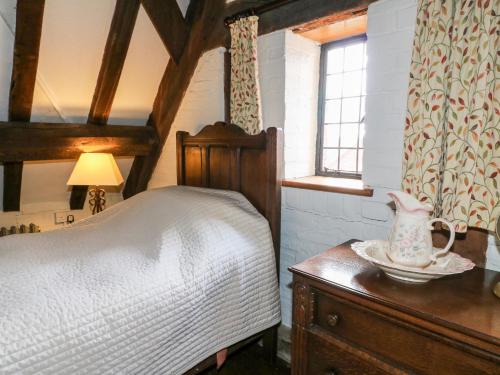 a bedroom with a bed and a table with a vase on it at Gatehouse Croft in Newton Regis