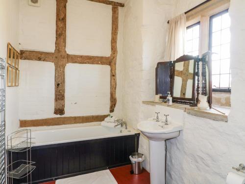 a bathroom with a bath tub and a sink at Gatehouse Croft in Newton Regis