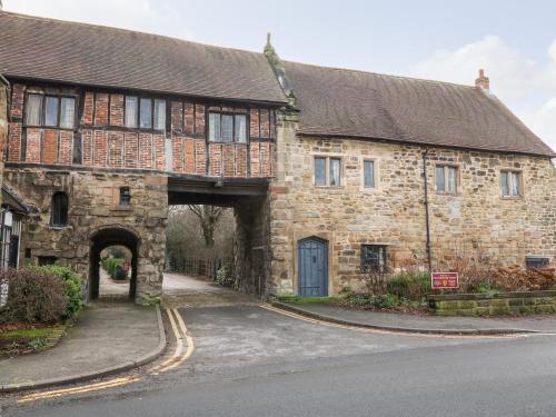 an old stone building with an archway in a street at Gatehouse Croft in Newton Regis