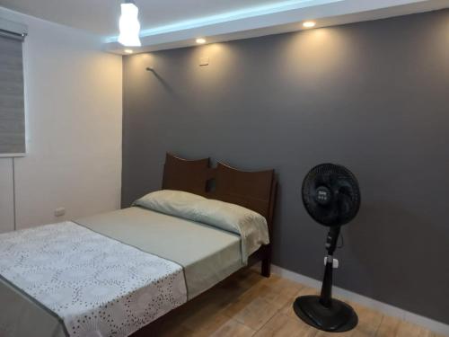 um quarto com uma cama e uma ventoinha ao lado de uma parede em Apartamento en Jamundi em Jamundí