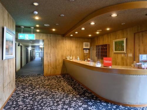 鯖江市にあるTabist ビジネスホテル おさむらの建物内の長いカウンター付ロビー