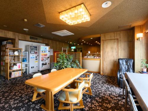 a conference room with a wooden table and chairs at Tabist Business Hotel Osamura in Sabae