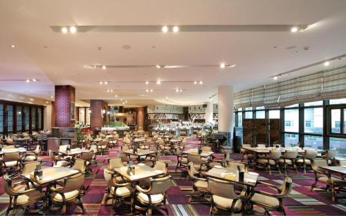 un restaurante con mesas y sillas en un edificio en City Hotel Xiamen-Free Welcome Fruits, en Xiamen