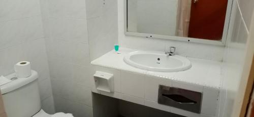 a white bathroom with a sink and a mirror at Hotel Seri Malaysia Ipoh in Ipoh