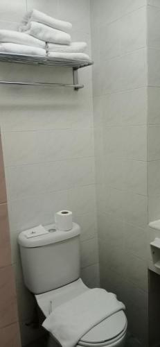 a white bathroom with a toilet and some towels at Hotel Seri Malaysia Ipoh in Ipoh