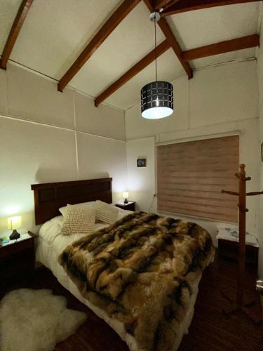 een slaapkamer met een groot bed en een grote deken bij hospedaje familiar Esperanza in Coihaique
