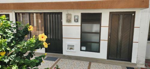 a house with black doors and a flower at El corazón del eje cafetero! La mejor ubicación in Pereira