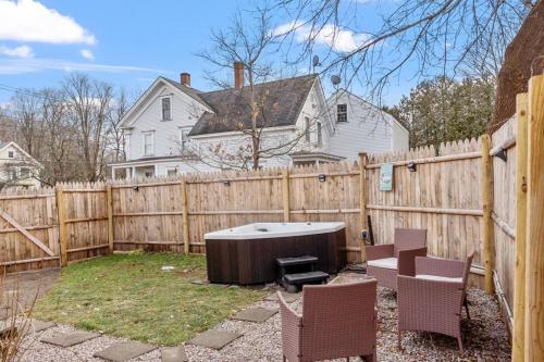 a backyard with a wooden fence and a hot tub at NEW!! Lovely unit w/ PRIVATE Hot Tub and patio! in Laconia