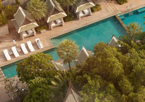曼谷的住宿－The Peninsula Bangkok，享有棕榈树游泳池的顶部景致