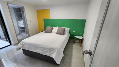 um quarto com uma cama grande e uma cabeceira verde em El corazón del eje cafetero! La mejor ubicación em Pereira