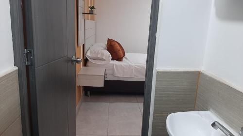 Baño pequeño con cama y lavabo en Aparta-Estudio en Medellín
