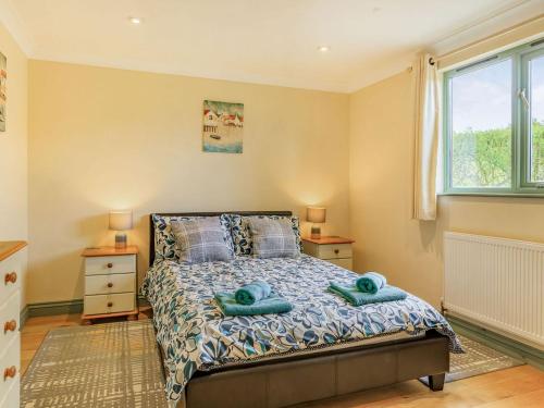 a bedroom with a bed with two towels on it at Bluebell Lodge in Holsworthy