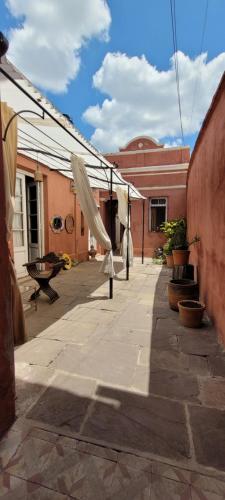 サルタにあるPunto Salta Hostelの建物の前に白い傘が置かれたパティオ