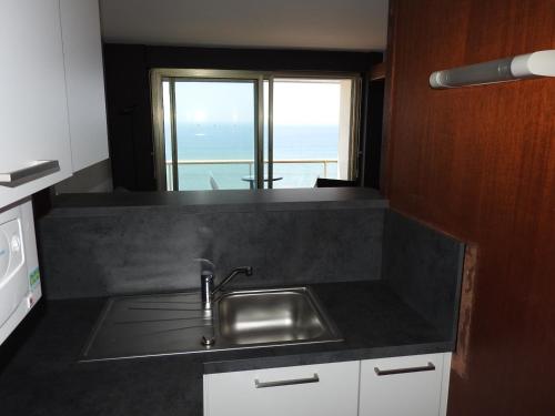 - une cuisine avec évier et vue sur l'océan dans l'établissement Appartement Les Sables-d'Olonne, 2 pièces, 5 personnes - FR-1-92-639, à Les Sables-dʼOlonne