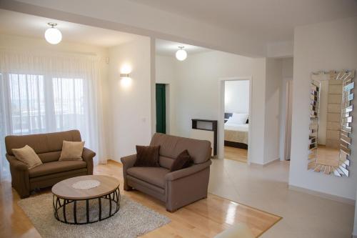 a living room with two chairs and a table at Apartments DYANA in Novalja