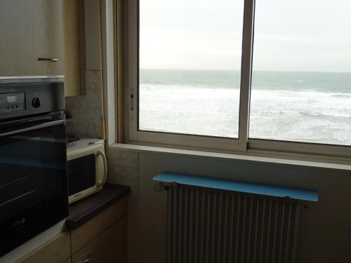 une cuisine avec une fenêtre donnant sur l'océan dans l'établissement Appartement T3 avec balcon aux Sables-d'Olonne - FR-1-92-803, à Les Sables-dʼOlonne