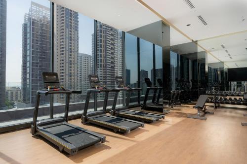 a gym with a row of treadmills and windows at Staybridge Suites Bangkok Sukhumvit by IHG in Bangkok