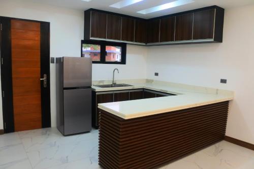 a kitchen with wooden cabinets and a stainless steel refrigerator at Aurora Villas and Cabin Resort in Clark