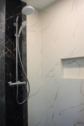 a shower in a bathroom with marble walls at Aurora Villas and Cabin Resort in Clark