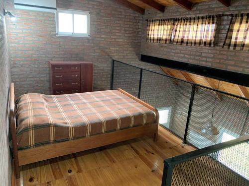 a attic room with a bed and a staircase at Casa Departamento Funes Buena Vista Cochera Pileta in Funes