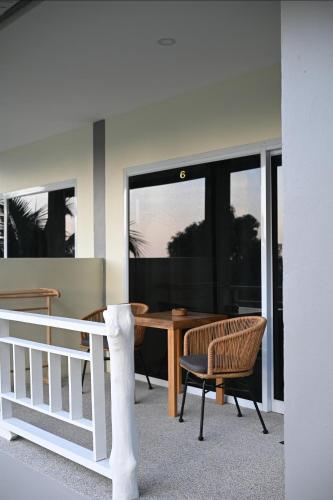 a dining room with a table and chairs and windows at Bao Village in Haad Yao
