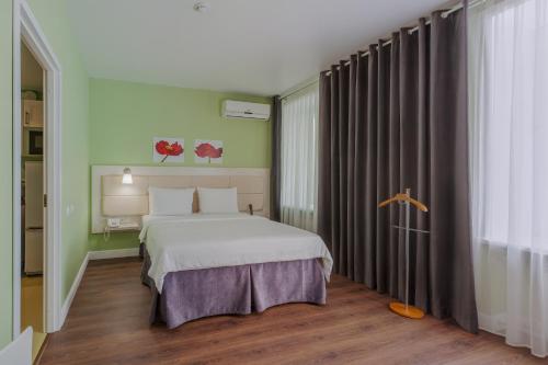 a bedroom with a bed and a large window at Dom Hotel Apart in Krasnoyarsk