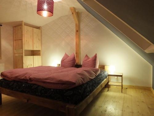 ein Schlafzimmer mit einem roten Bett im Dachgeschoss in der Unterkunft Waldhaus Bielatal in Bielatal