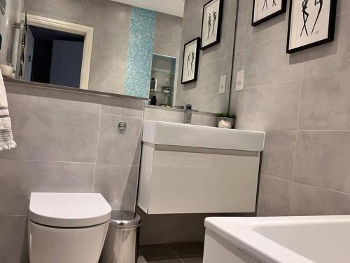 a bathroom with a white toilet and a sink at Lovely flat near Holland Park in London