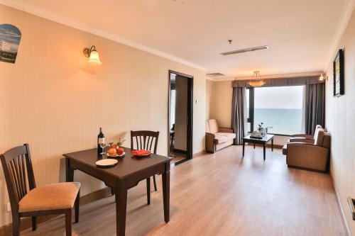 a dining room and living room with a table and chairs at Saigon Quy Nhon Hotel in Quy Nhon