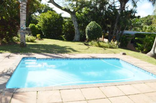 a swimming pool in a yard with trees at Sindy's Chalets in Margate