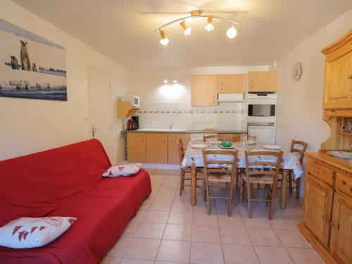 un salon avec un canapé rouge et une table dans l'établissement Appartement 6 personnes avec balcon, cœur du vieux village, proche remontées mécaniques et commerces - FR-1-623-332, aux Gets