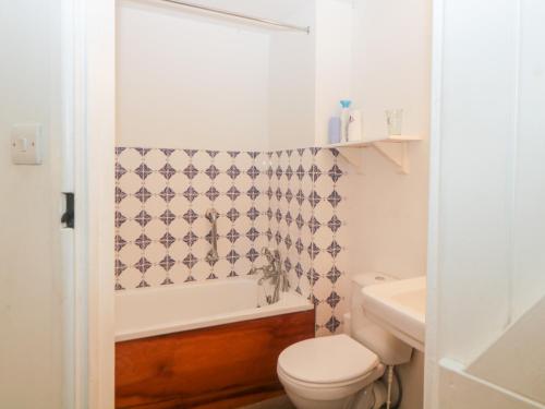 a bathroom with a toilet and a tub and a sink at The Cider Barn in Kingsbridge