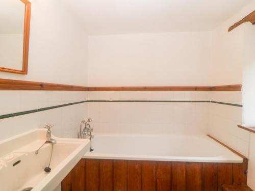 a bathroom with a bath tub and a sink at The Cider Barn in Kingsbridge