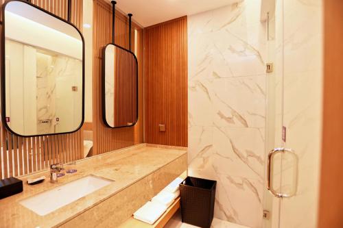 a bathroom with a sink and a shower at 无锡花园大酒店 in Wuxi