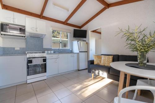 Myola的住宿－Tasman Holiday Parks - Myola，厨房以及带沙发和桌子的客厅。