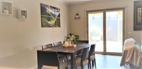 a dining room with a black table and chairs at Central Villa/Two King beds/Disabled/Family/Pets in Maryborough