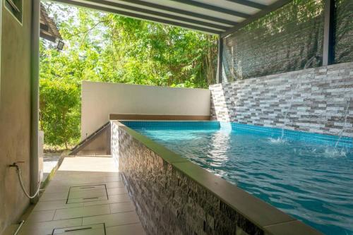 ニライにある5 Bedrooms Homestay with Private Pool (SEROJA)のレンガ造りの家のスイミングプール