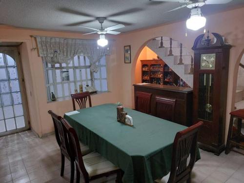 a dining room with a green table and chairs at Amplia y Hogareña Casa in Aguascalientes