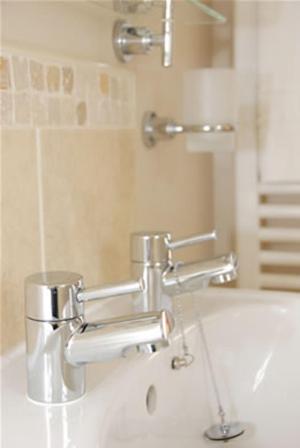 a bathroom with a sink with two faucets at The Carlton in Rugby