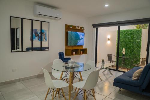 a living room with a glass table and chairs at Planta Baja, a 10 minutos de la playa, Gran alberca y Mini Golf!! in Mazatlán