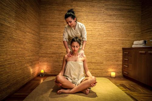 a woman sitting on top of a woman in a room at Monte Casa SPA & Wellness in Petrovac na Moru