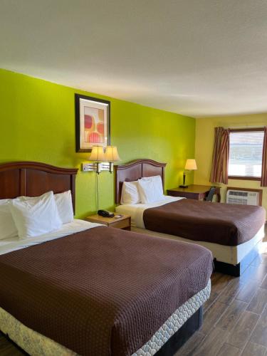 two beds in a hotel room with green walls at Linder Motor Lodge in Homer