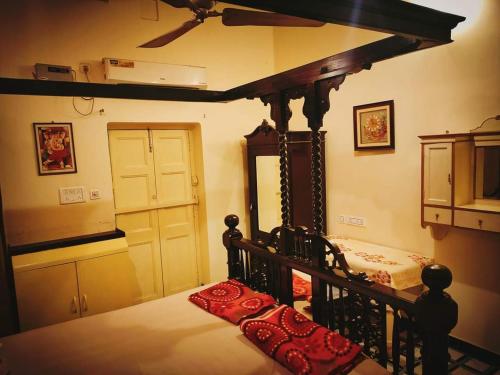 ein Schlafzimmer mit einem Himmelbett und einem Spiegel in der Unterkunft OH Kolkata - Sutanuti Homestay in Kalkutta