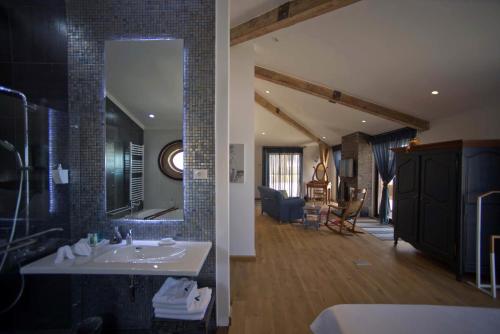 a bathroom with a sink and a mirror and a living room at L'Auberge de la Mer in Batroûn