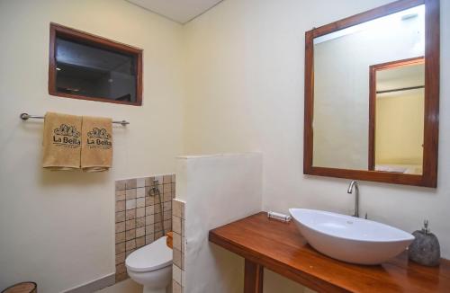 a bathroom with a sink and a toilet and a mirror at La Bella - Hotel Villa & Spa in Gili Trawangan