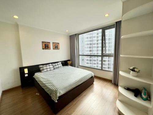 Un dormitorio con una cama y una ventana grande. en BOM HOMES- VINHOMES TIMES CITY & PARK hilll, en Hanói
