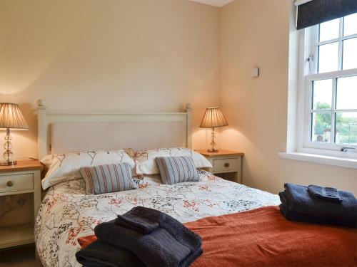 a bedroom with a bed with two lamps and a window at The Old Gasworks Building in Montrose