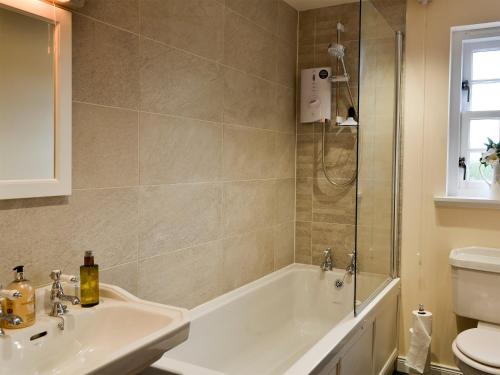 a bathroom with a tub and a sink and a toilet at The Old Gasworks Building in Montrose