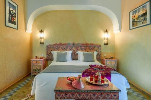 a bedroom with a bed and a table with food on it at Double room in a charming villa in the heart of Marrakech palm grove in Marrakesh